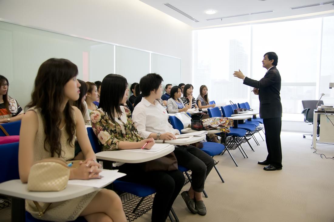 A graduate class at the city campus with Bangkok visible through the windows