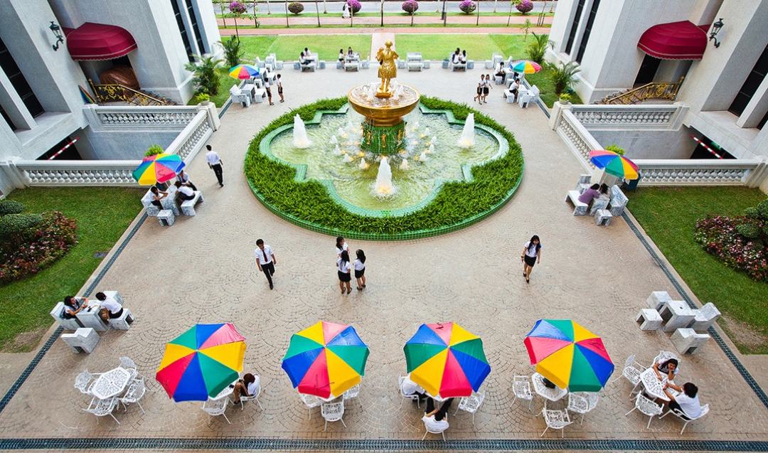 Students in the campus courtyard around the golden fountain